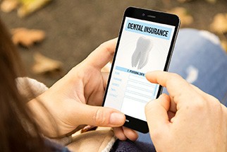 A woman looking at a dental insurance app on her phone