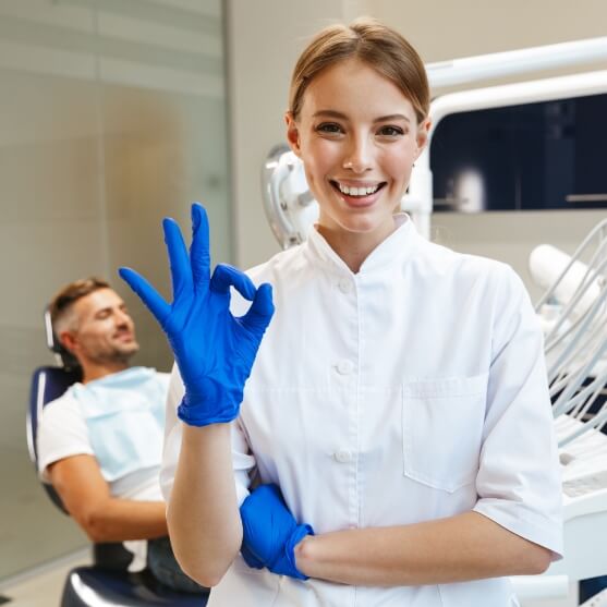 Dentist giving okay sign with resting dental patient