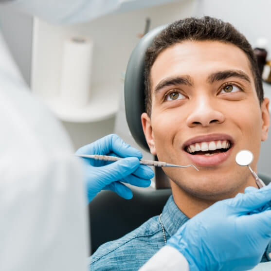 Man receiving dental checkup and teeth cleaning