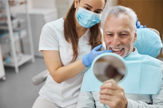 An aging gentleman admiring his new dental implant