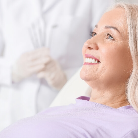 Woman smiling after undergoing the four step dental implant process