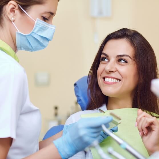 Woman and her dentist discussing the benefits of dental implants