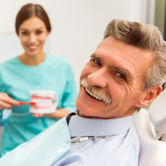 Man with dentures smiling in dental chair