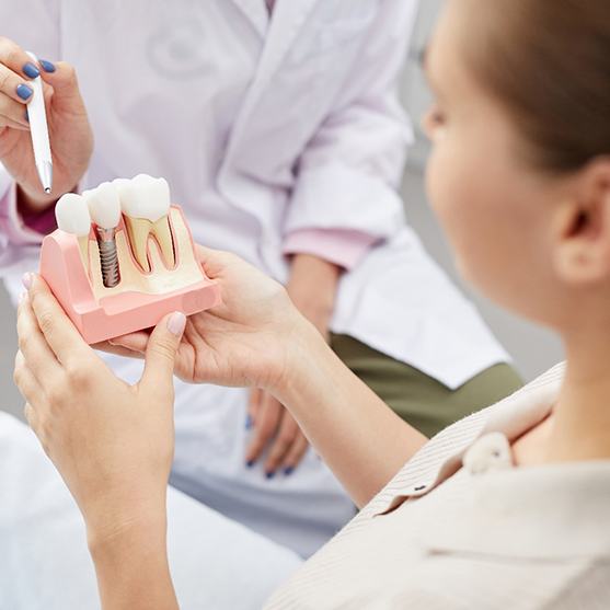 Dentist showing a dental implant to a patient