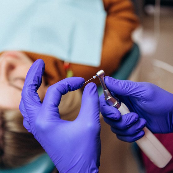 Dentist preparing drill to begin root canal