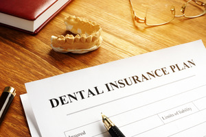 Dental insurance form on a desk with model of teeth