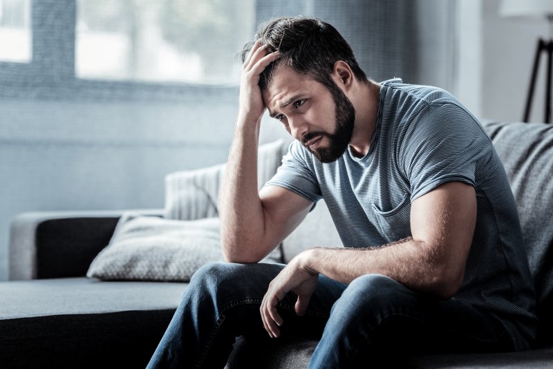 An unhappy, bearded man experiencing depression